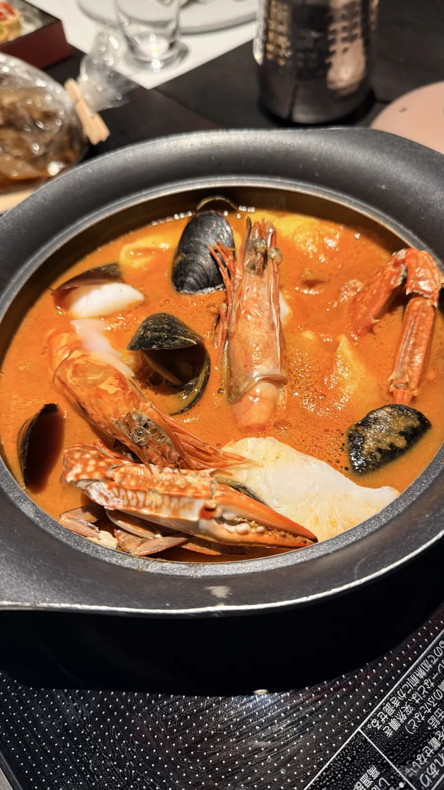 海老や蟹、貝、白身魚が入った鍋を卓上IHに載せた客室での夕食