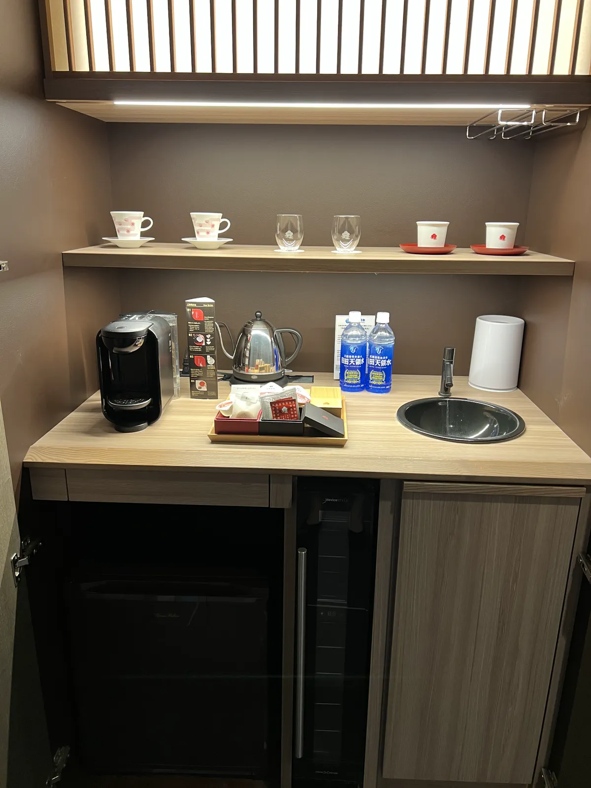 客室のミニキッチン。棚にはカップやグラス、電気ケトル、ミネラルウォーター