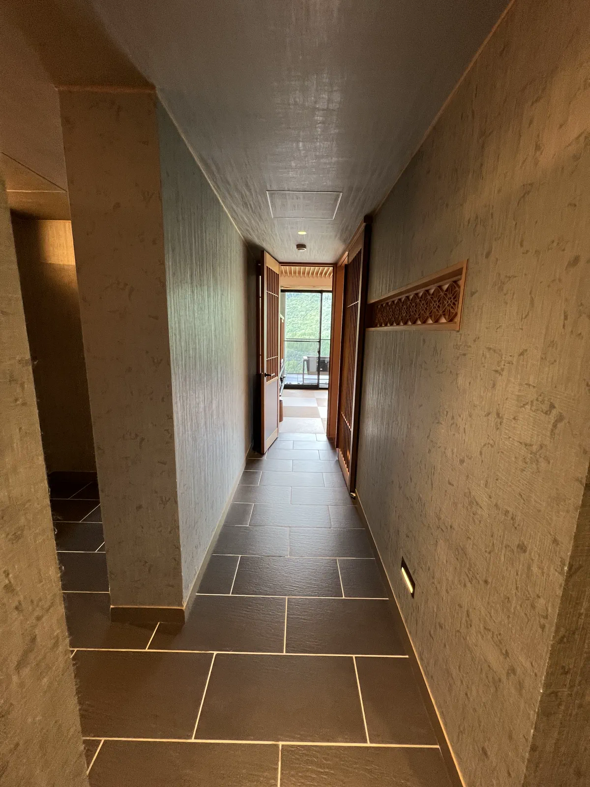 客室の廊下。落ち着いた雰囲気で、奥にはテラスが見える