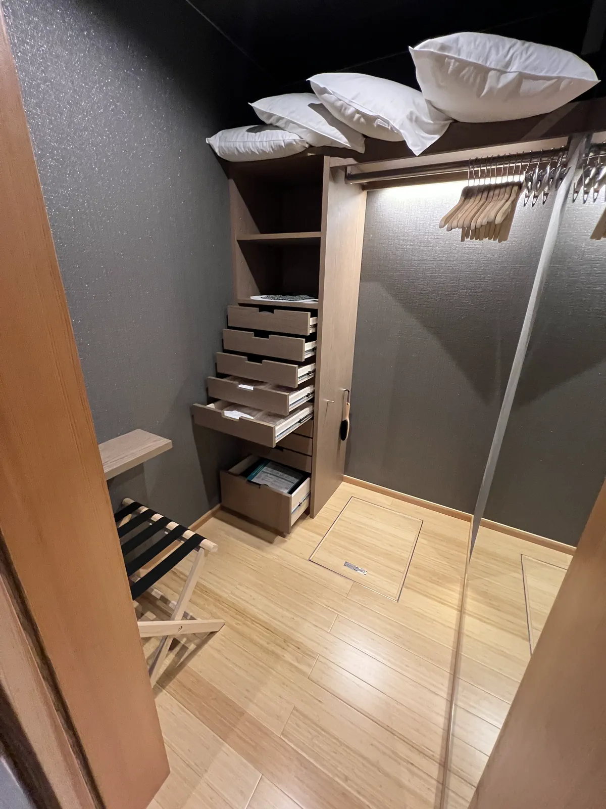 旅館の客室にある広々としたクローゼット。ハンガーや引き出し、荷物置き台も完備。