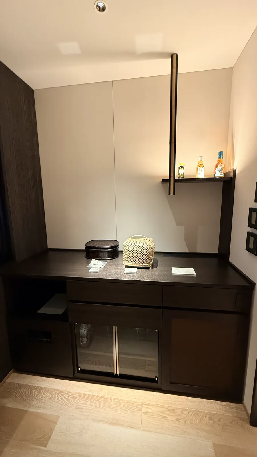 ホテルの部屋の様子。棚にはボトルが並び、冷蔵庫が設置されている。