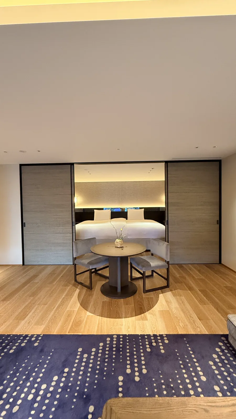 ベッドとテーブルセットがある客室