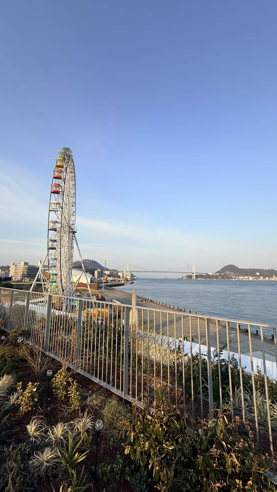 海辺のテラスから見える観覧車と関門橋の風景