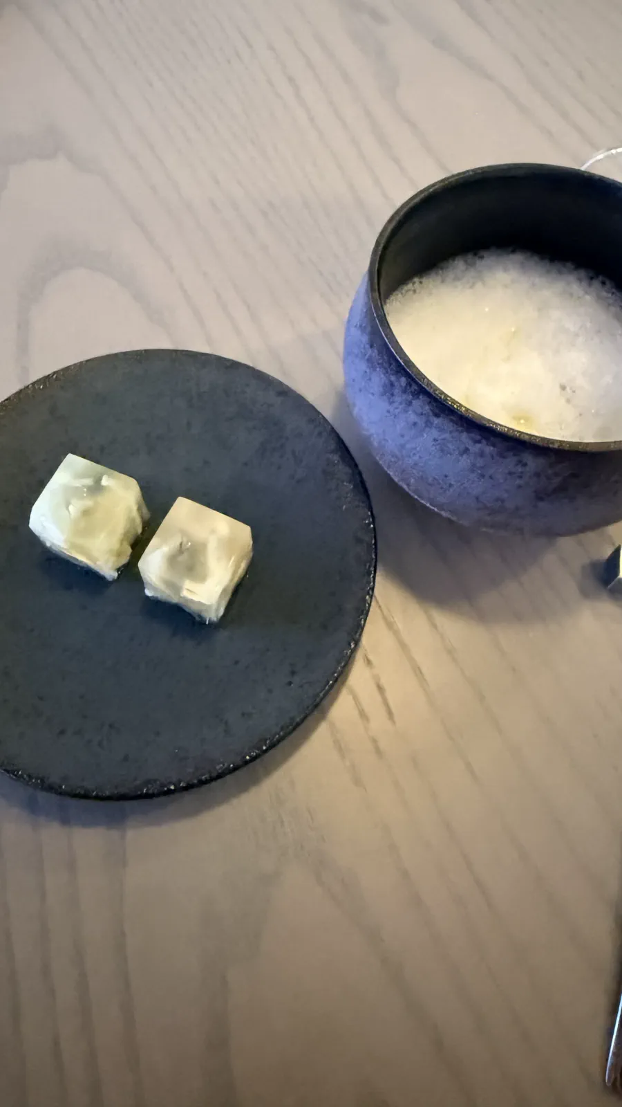 小皿と泡をのせた器で提供されたふぐ皮のインサラータとズッパ