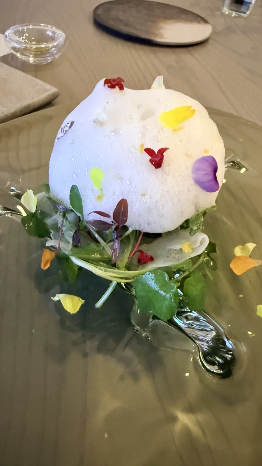 ふぐのカルパッチョに柑橘のスキューマと花びらを重ねた一皿